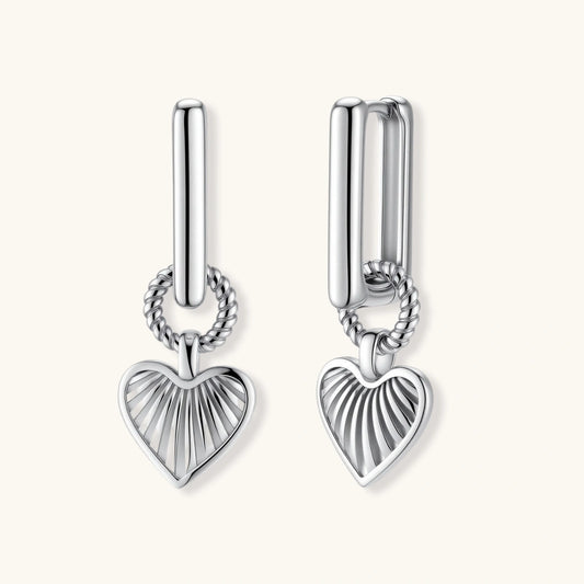 Pair of silver heart-shaped earrings on a white background