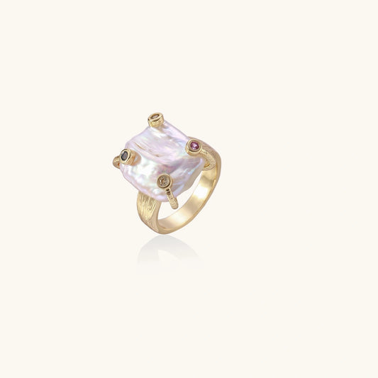 Gold ring with a large pearl-like stone on a white background