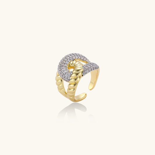 Gold and silver ring with intricate design on a white background