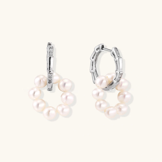Pair of pearl hoop earrings on a white background