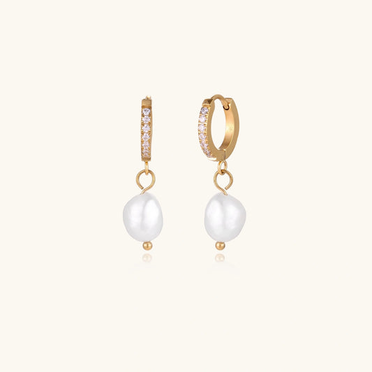 Gold hoop earrings with pearl drops on a white background