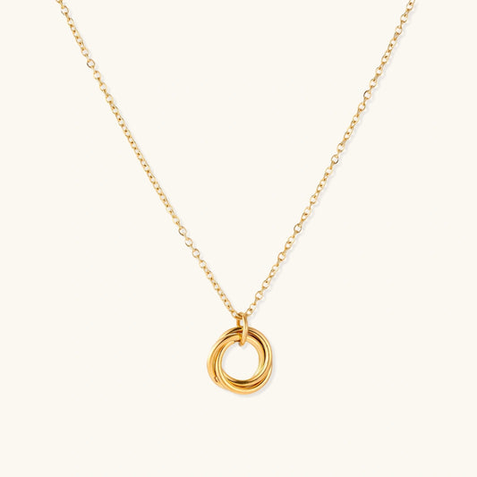 Gold necklace with a circular pendant on a white background
